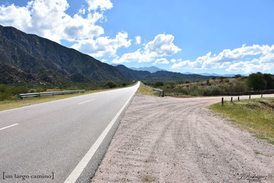 Road leading towards mountains against sky