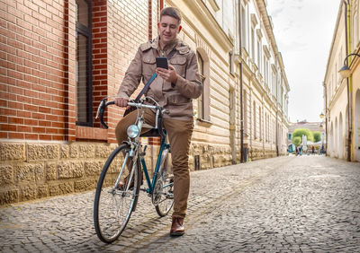 Rear view of man riding bicycle on street