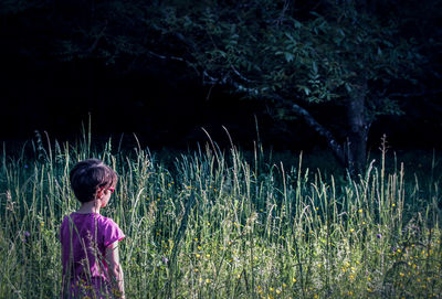 Rear view of girl standing on field