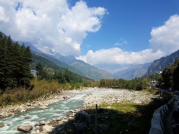 Scenic view of river and mountains against sky