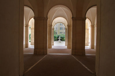 View from inside the arches of palazzo barberini in rome. in the background an external fountain.