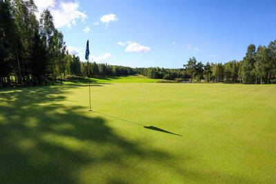 Scenic view of golf course against sky