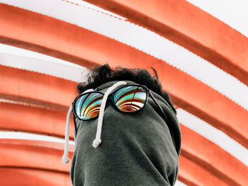 Close up view of man hiding his face with his shirt top and sunglasses