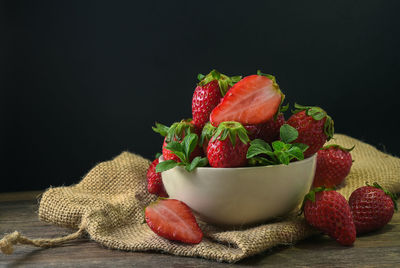 Close-up of strawberries in bowl against black background