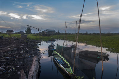 Boats moored in river against sky