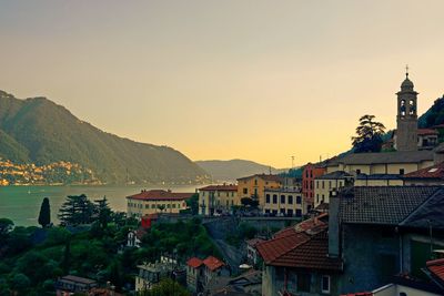 Houses in town against sky during sunset