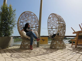 Full length of woman relaxing on seat