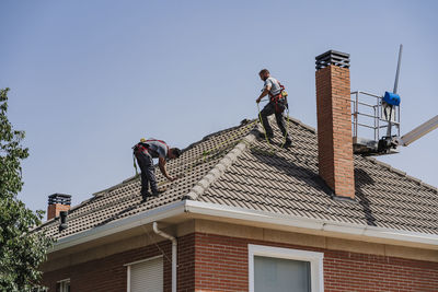 Technicians working on house rooftop