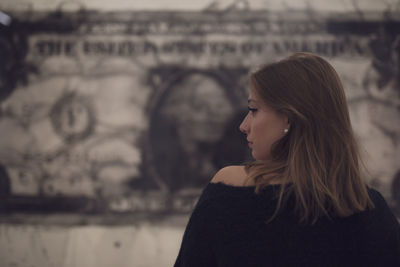 Fashionable young woman in city at night