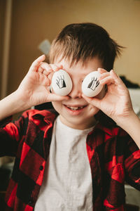 Funny picture of a boy with eggs instead of eyes. eggs with painted eyes. preparing for easter 