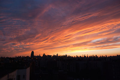 High angle view of silhouette buildings against sky during sunset