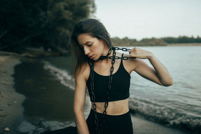 Young woman with arms raised standing at beach