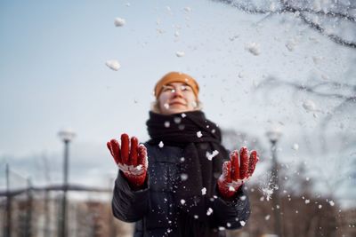 Young woman playing with snow during winter