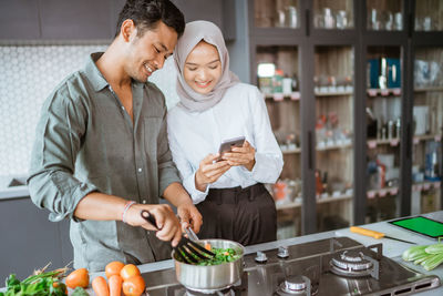 Portrait of senior man using mobile phone while standing in cafe