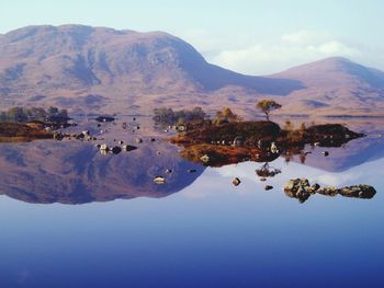 Scenic view of lake and mountains against sky