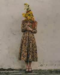 Rear view of woman standing against wall