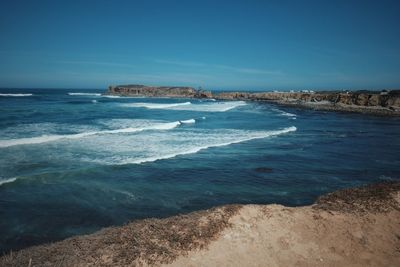 Scenic view of sea against clear blue sky
