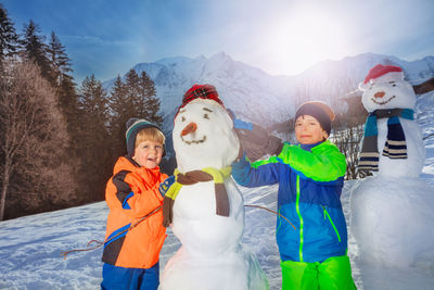 Portrait of smiling family standing against snowcapped mountains
