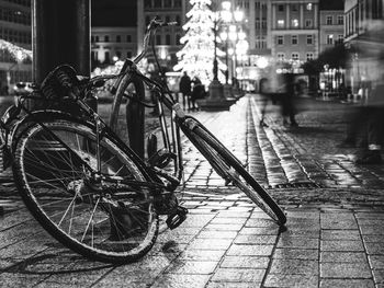 Bicycle in the night old city center on background bokeh light flare in night architecture