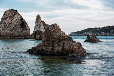 Scenic view of rocks in sea against sky