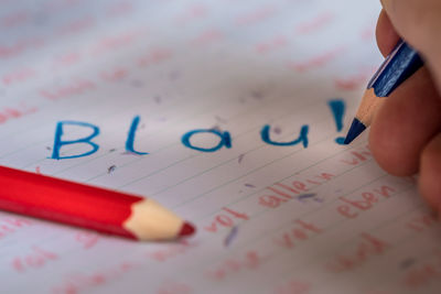 Close-up of a red and a blue pen and the text written on paper 