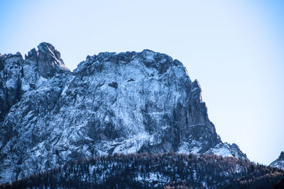 Low angle view of frozen mountain against clear sky