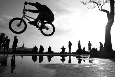 Low angle view of men on silhouette people against sky