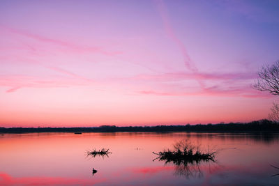 Scenic view of lake against romantic sky at sunset