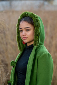 Close-up of young woman standing against plants