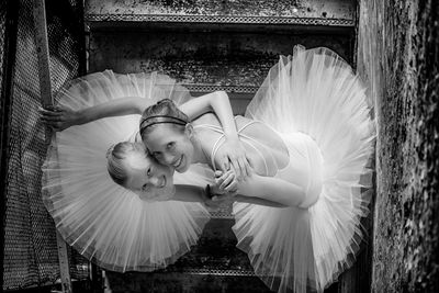 Directly above portrait of smiling woman and girl wearing tutu on steps