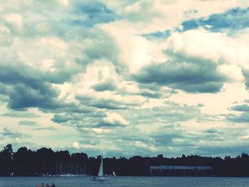 Scenic view of calm river against cloudy sky