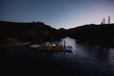 Silhouette boat in sea against clear sky