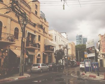 Buildings in city against cloudy sky