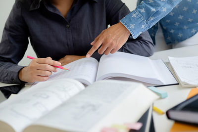 Midsection of man working on book