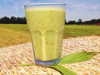 Close-up of beer glass on field