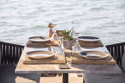 Beautiful served table of a modern cafe by the sea with dishes and flowers. 