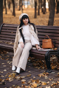 Woman sitting on bench in park