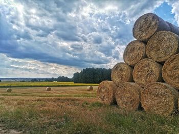 Hay bales on field against sky