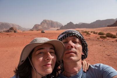 Portrait of couple at desert against clear sky