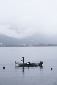 Man standing in motorboat on lake