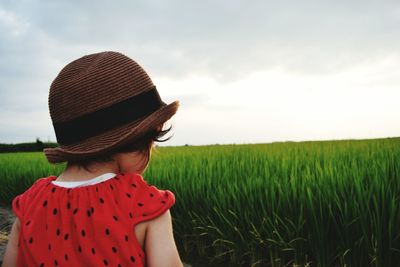 Rear view of girl standing on field