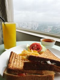 Close-up of breakfast served on table by window