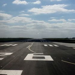 Airplane on airport runway against sky