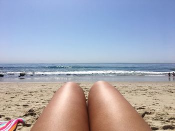 Low section of woman relaxing on beach