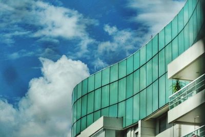 Low angle view of modern building against cloudy sky