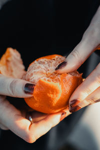 Close-up of hand holding orange slice