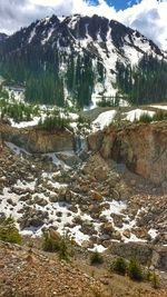 Scenic view of lake by snow mountains against sky