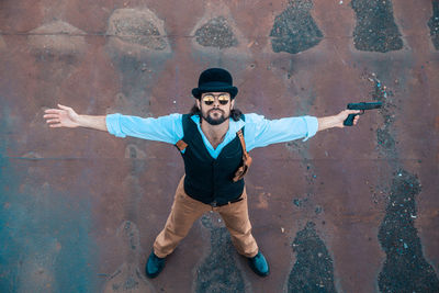 Portrait of young man standing against wall