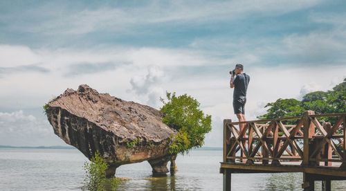 Man standing by sea against sky