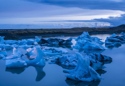 Frozen lake against sky during winter